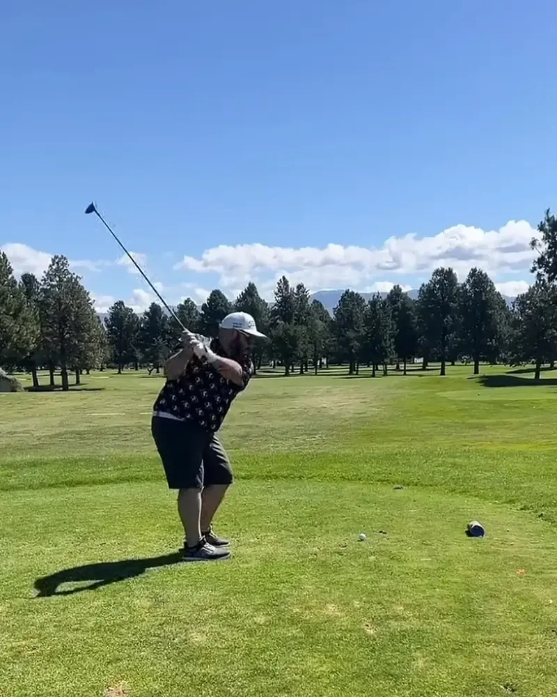 Ben Campos, owner of Honours Golf Sim, mid-swing on the course